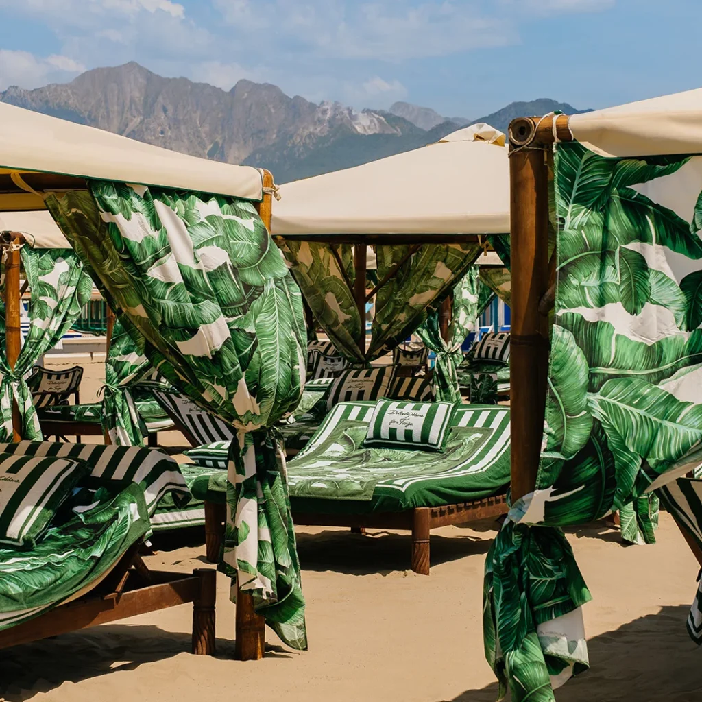 Luxury beach cabanas lined with green banana leaf pattern fabric from Dolce & Gabbana at the Twiga club in Forte dei Marmi.