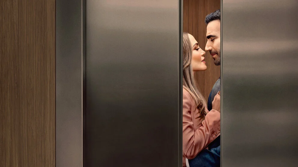 A romantic moment between Jennifer Lopez and Brett Goldstein inside a closing elevator in the movie Office Romance.