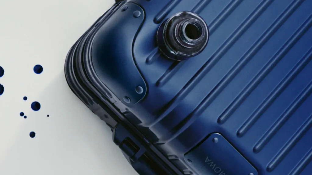 Close-up of the anodised aluminium finish of a RIMOWA Ink Blue suitcase with an inkwell.