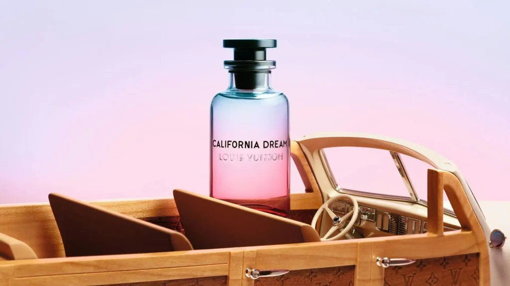 Close-up of the Louis Vuitton California Dream perfume bottle sitting inside the wooden Alex Israel Woody Wagon miniature car.