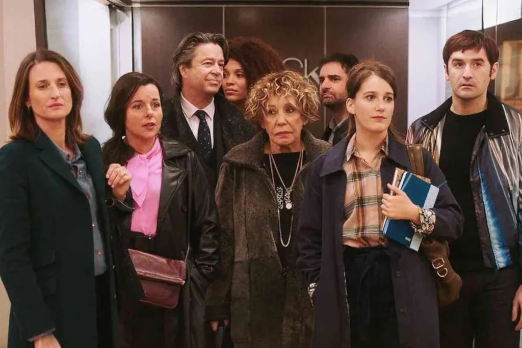 Main characters of the Call My Agent movie standing surprised in the ASK agency offices.