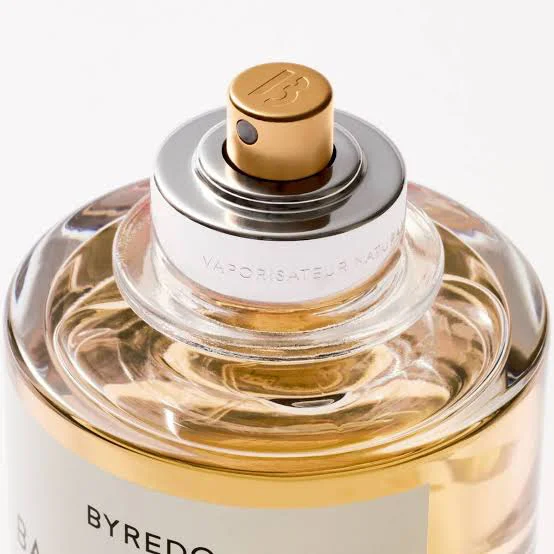 Close-up of a Byredo perfume bottle featuring a gold spray nozzle and transparent glass