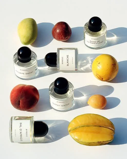 Byredo perfumes including Bal d'Afrique, Blanche and Gypsy Water arranged with colorful summer fruits