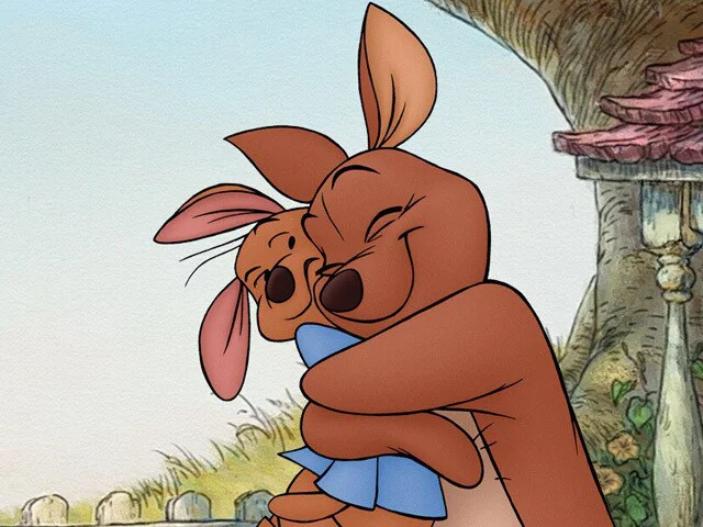 Kanga hugs her young kangaroo Roo beside a tree in the Hundred Acre Wood.